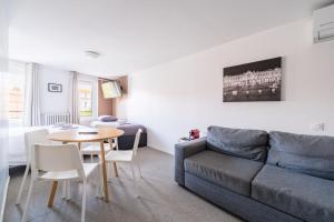 a living room with a couch and a table at Premier Acte - Chambre Spacieuse Sur Les Allées in Toulouse +2 photos