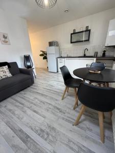 a living room with a black couch and a table at Le Thannaron in Bourg-lès-Valence