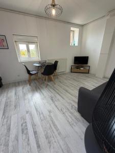 a living room with a table and chairs and a couch at Le Thannaron in Bourg-lès-Valence