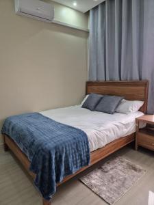 a bedroom with a bed with a blue blanket on it at T&M Estates Lusaka in Chilanga