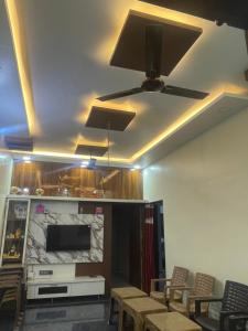 a room with a ceiling fan and tables and chairs at VISHNU DATTA HOMESTAy in Bandanwāda