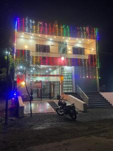 a motorcycle parked in front of a building with christmas lights at VISHNU DATTA HOMESTAy in Bandanwāda
