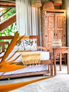 a bedroom with two beds and a table at Casa Felina in Ilha de Boipeba