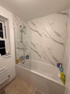 ein Badezimmer mit Dusche und einer weißen Marmorwand in der Unterkunft Brampton Park - double room in Brampton Grange
