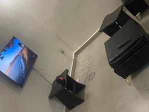 a room with a tv and a computer on the floor at Kivu Breeze Apartment in Gisenyi