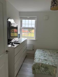 ein Schlafzimmer mit Bett, Schreibtisch und Fenster in der Unterkunft Brampton Park - double room in Brampton Grange