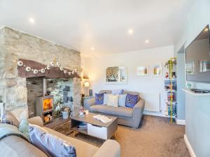 a living room with a couch and a fireplace at Hyfrydle Cottage in Talysarn
