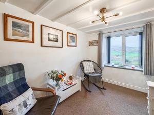 a living room with a chair and a window at Hyfrydle Cottage in Talysarn