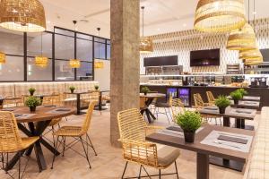 a restaurant with tables and chairs and a bar at THE APARTMENT by assethoteles in Torrejón de Ardoz