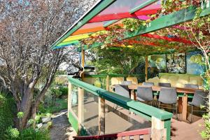 a patio with a table and chairs under a colorful roof at Birdcage - King Bed - Walk to CBD in West Hobart