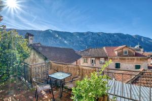 a table on a balcony with mountains in the background at Best view! Rooftop with Garden - Old Town Nr404 in Kotor
