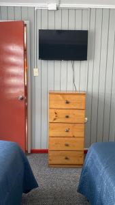 a bedroom with a dresser and a television on a wall at Hostal Santa Sabina in Concepción +9 photos