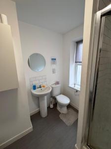 a white bathroom with a toilet and a sink at King Street Rooms in Liverpool