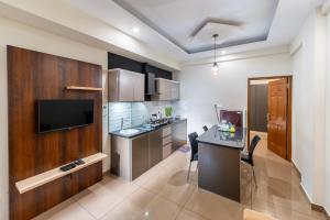 a kitchen with a desk and a television in a room at Grace Apart Hotel @Kochi in Cochin