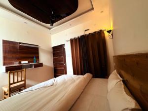 a bedroom with a bed with a wooden headboard and a window at GJ Wellness And Stay in Rishīkesh