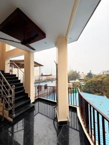 a balcony with stairs and a view of the water at GJ Wellness And Stay in Rishīkesh