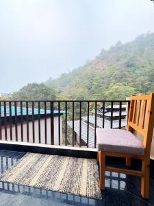 a chair on a balcony with a view of the water at GJ Wellness And Stay in Rishīkesh