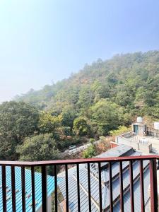 a balcony with a view of a mountain at GJ Wellness And Stay in Rishīkesh +15 photos