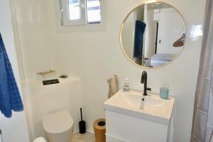 a white bathroom with a sink and a mirror at Villa B - Kamari Village in Aliko Beach +70 photos