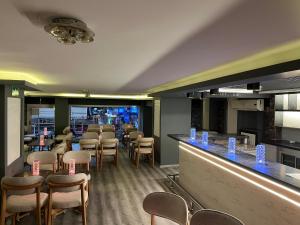 ein Restaurant mit Bar, Stühlen und Tischen in der Unterkunft Artan Hotel in Isparta
