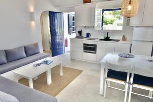 a living room with a couch and a table at Villa B - Kamari Village in Aliko Beach