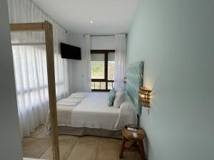 a small bedroom with a bed and a window at El Escondido de Zahara in Zahara de los Atunes