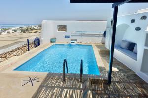 a swimming pool on the side of a house at Villa B - Kamari Village in Aliko Beach