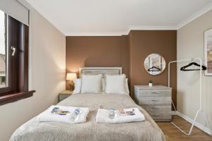 a bedroom with a bed with two towels on it at Glebe House in Uphall