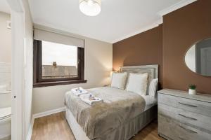 a small bedroom with a bed and a window at Glebe House in Uphall