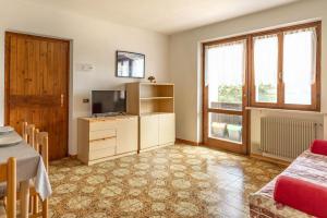 a living room with a television and a table at Casa Maria in Mezzolago