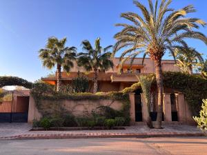 a building with palm trees in front of it at villa Bidouane in Marrakesh