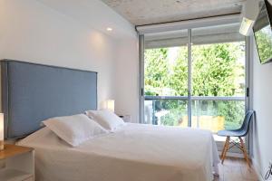 a bedroom with a bed and a large window at Oceana Suites Mansa Inn in Punta del Este