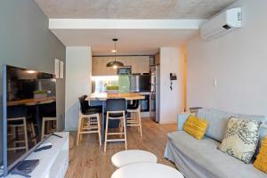 a living room and kitchen with a couch and a table at Oceana Suites Mansa Inn in Punta del Este +32 photos