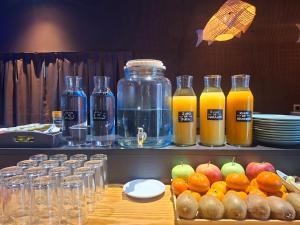ein Tisch mit Flaschen Saft, Äpfeln und Orangen in der Unterkunft Hotel Oriente in Teruel