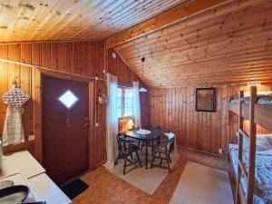 a room with a table in a cabin with a bedroom at Långseruds Stugby Nature Cabins in Byn
