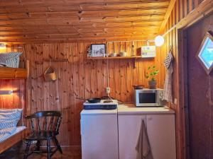 a small kitchen with a refrigerator and a microwave at Långseruds Stugby Nature Cabins in Byn +44 photos
