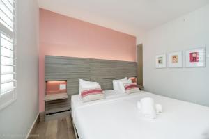 a bedroom with a large white bed with a headboard at The Julia Hotel in Miami Beach