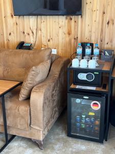 a brown couch sitting next to a table with bottles of water at BMG Hotel by Grigoryans Group in Goris
