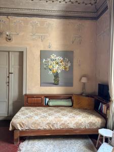 a bedroom with a bed with a vase of flowers on the wall at adagio b&b in Faenza