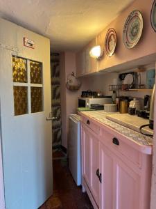 a kitchen with pink cabinets and a pink door at adagio b&b in Faenza