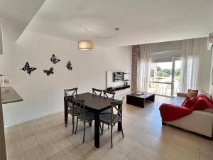 a living room with a dining room table with butterflies on the wall at Sea Point By D&G in Carilo