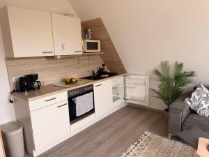 a kitchen with white cabinets and a stove top oven at Yunis Landhaus in Grömitz