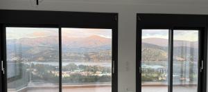 a room with three windows with a view of a mountain at 360 Skyline Suite, Argostoli in Argostoli