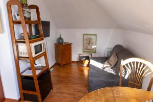 a living room with a couch and a book shelf at Studio spacieux, route des vins in Rosheim