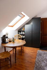 a room with a table and a kitchen with a window at Studio spacieux, route des vins in Rosheim
