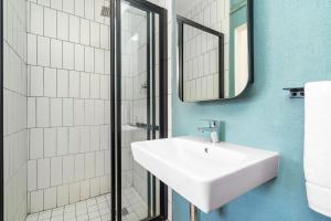 a bathroom with a white sink and a shower at Cape on Popham 21B in Bloubergstrand +25 photos