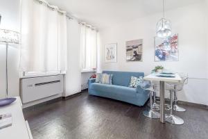 a living room with a blue couch and a table at NURAS - Joia city center in Alghero