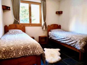 a bedroom with two twin beds and a window at Le Charme 1, Morgins in Morgins