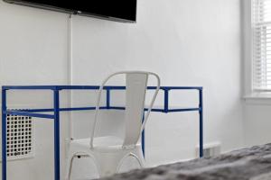 a white chair sitting in front of a blue desk at Dormont, Pittsburgh !A Spacious and Modern Private Bedroom with Shared Bathroom in Pittsburgh