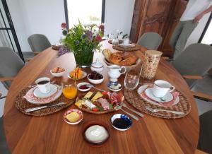a wooden table with breakfast food on it at Au Bon Cap in Hervelinghen